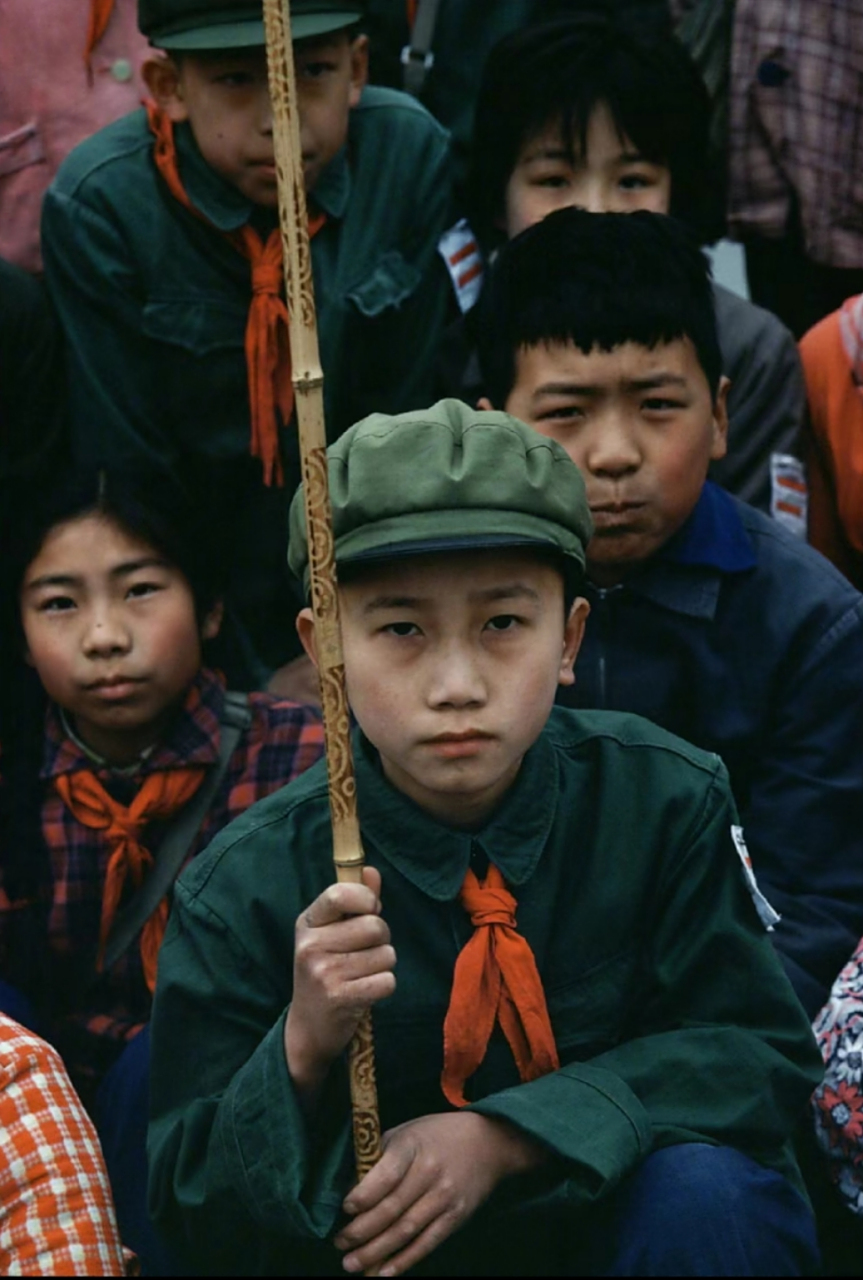 二十世纪七十年代老照片,学生们蹲在地上,其中一位穿着绿色衣服的学生
