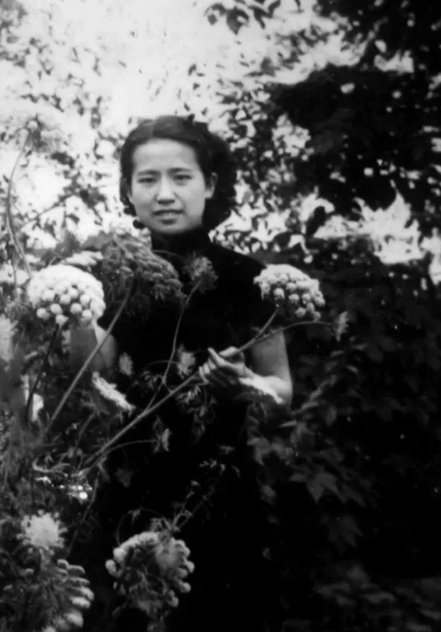 老舍妻子胡絮青罕见照片,她站在花丛中,一脸笑意.