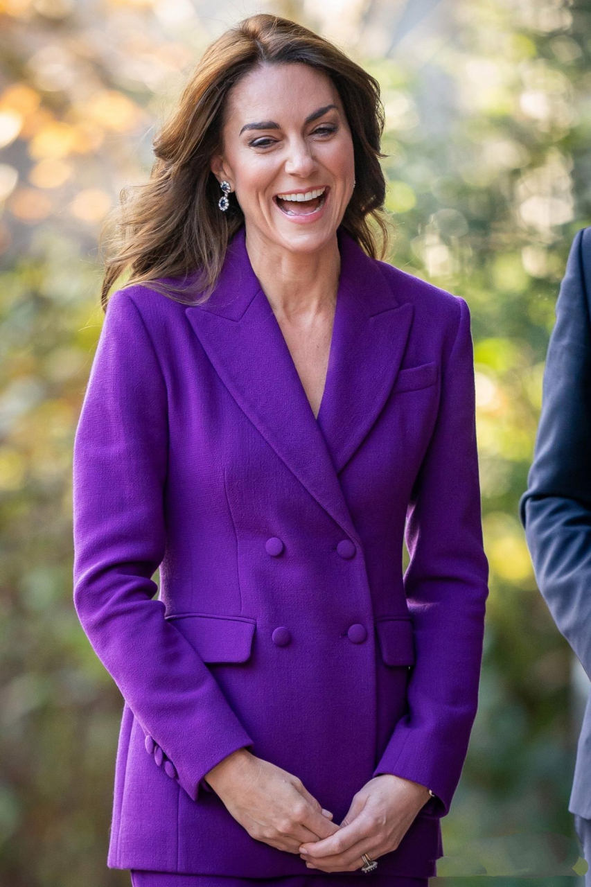 她戴着婆婆戴安娜王妃的蓝宝石耳环,身穿紫色西服发表演讲.