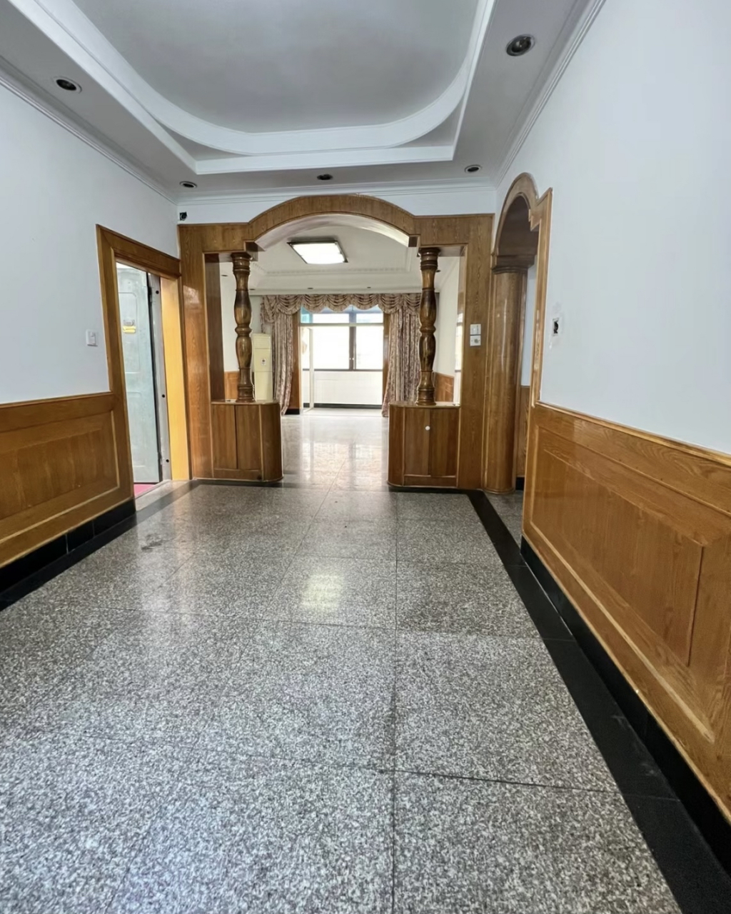 这是八九十年代典型的装修风格,水磨石地板,白色的墙面和木质的门框