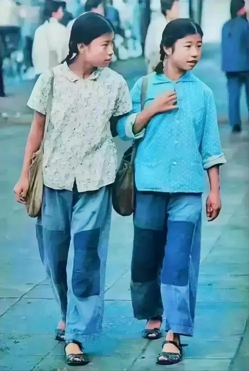 上世纪70年代,两个穿补丁衣服的女孩走在大街上,从穿着上看得出来她们