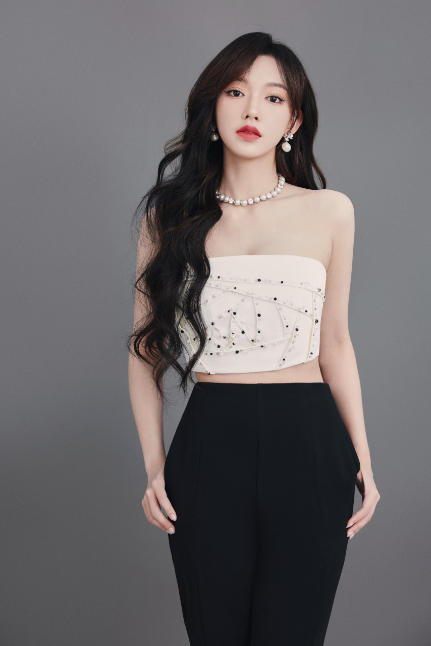 程潇身着露肩钉珠抹胸背心,搭配开叉长裤,尽显优雅气质.