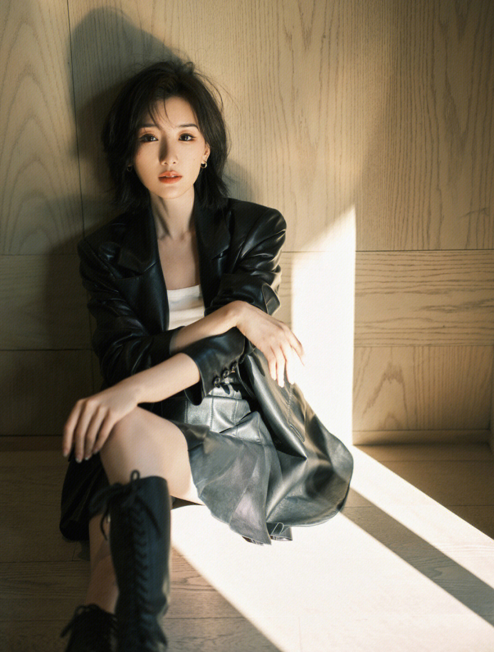 毛晓彤化身街头酷girl,白色绑带露脐背心配黑色皮夹克,皮裙,脚踩高筒