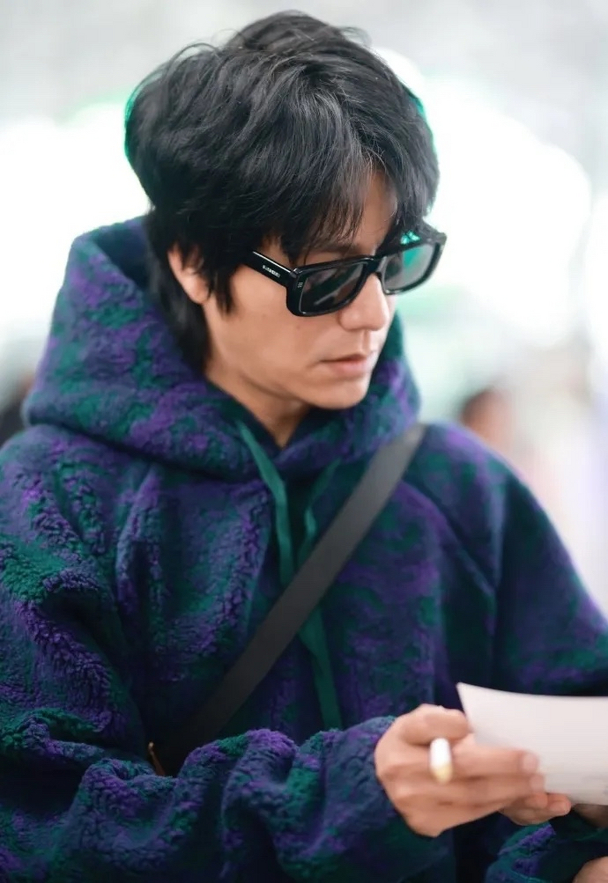 陈坤背着时尚的包包,还留着英俊的发型,戴着黑色的