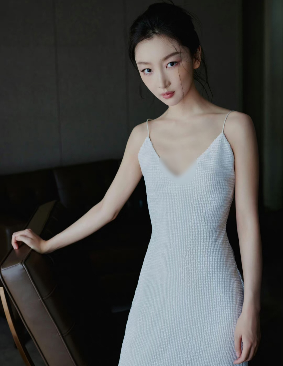 周冬雨一袭白色吊带礼服亮相,作为代言人出席活动神采奕奕,侧脸下颌线