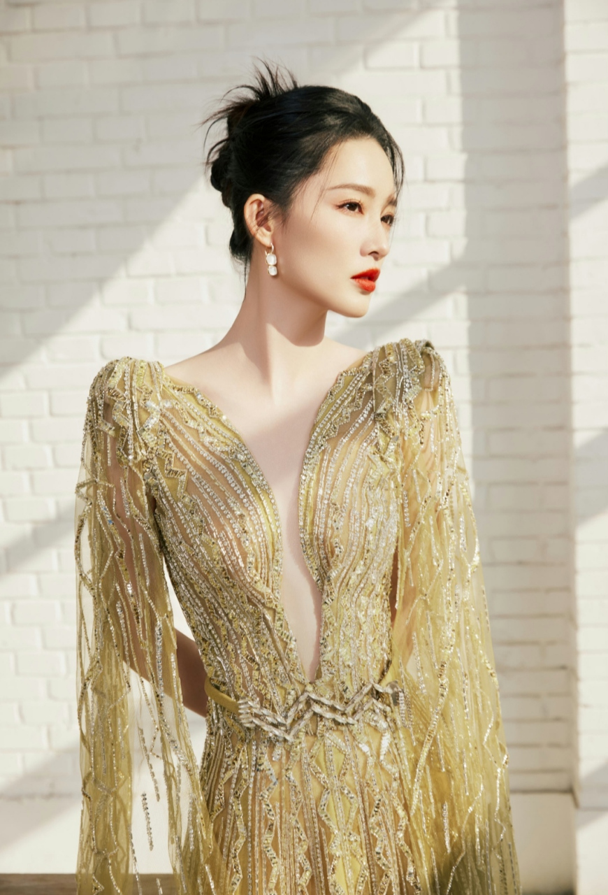 李沁,一袭鎏金长裙,背部镂空加上前方开衫的设计尽显高贵典雅,非常的