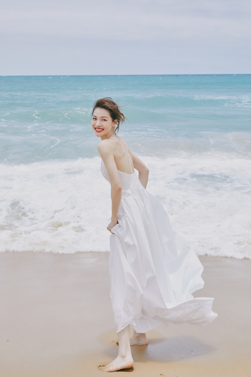 钟楚曦海边写真,一袭白色吊带裙,衬托出白皙的皮肤,大裙摆随风飘逸