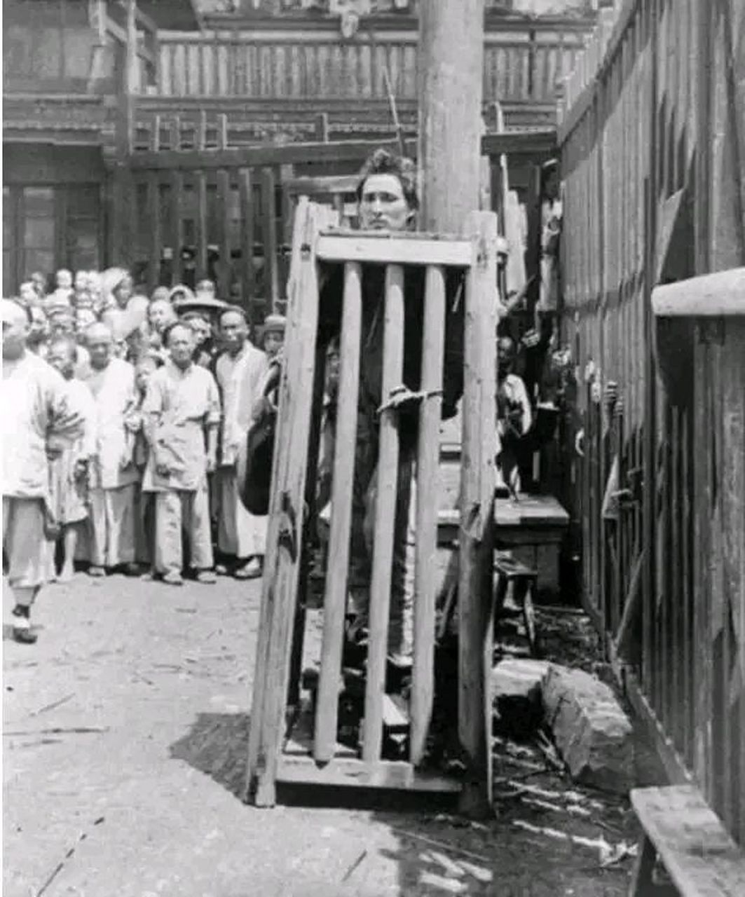 图片中的刑具叫做立枷,又叫站笼,是一种残忍的刑具.