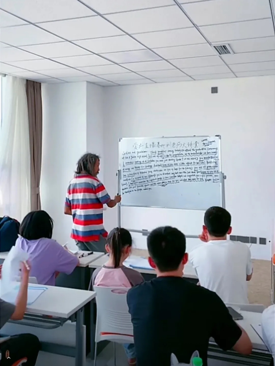 流浪大师刘彦宏在众多爱心人士的帮助下站在讲台上为孩子们讲课教孩子