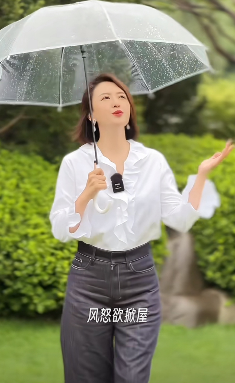 张蕾拍外景短片,为了节目效果特别撑了一把透明雨伞,配合她的白衬衫和