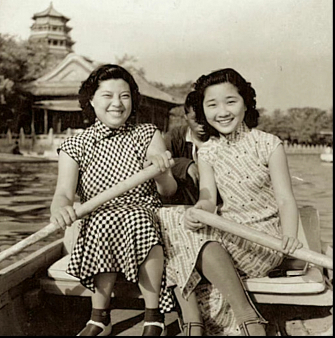 民国老照片,1941年,北京,两个穿着旗袍的女人正在泛舟游玩,从后面的