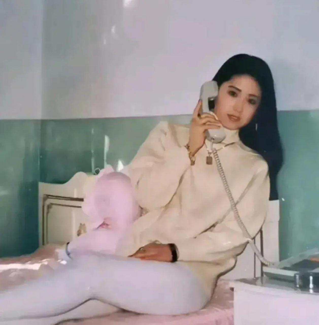 90年代,深圳某员工宿舍,一个年轻姑娘斜躺在床上打电话的老照片.