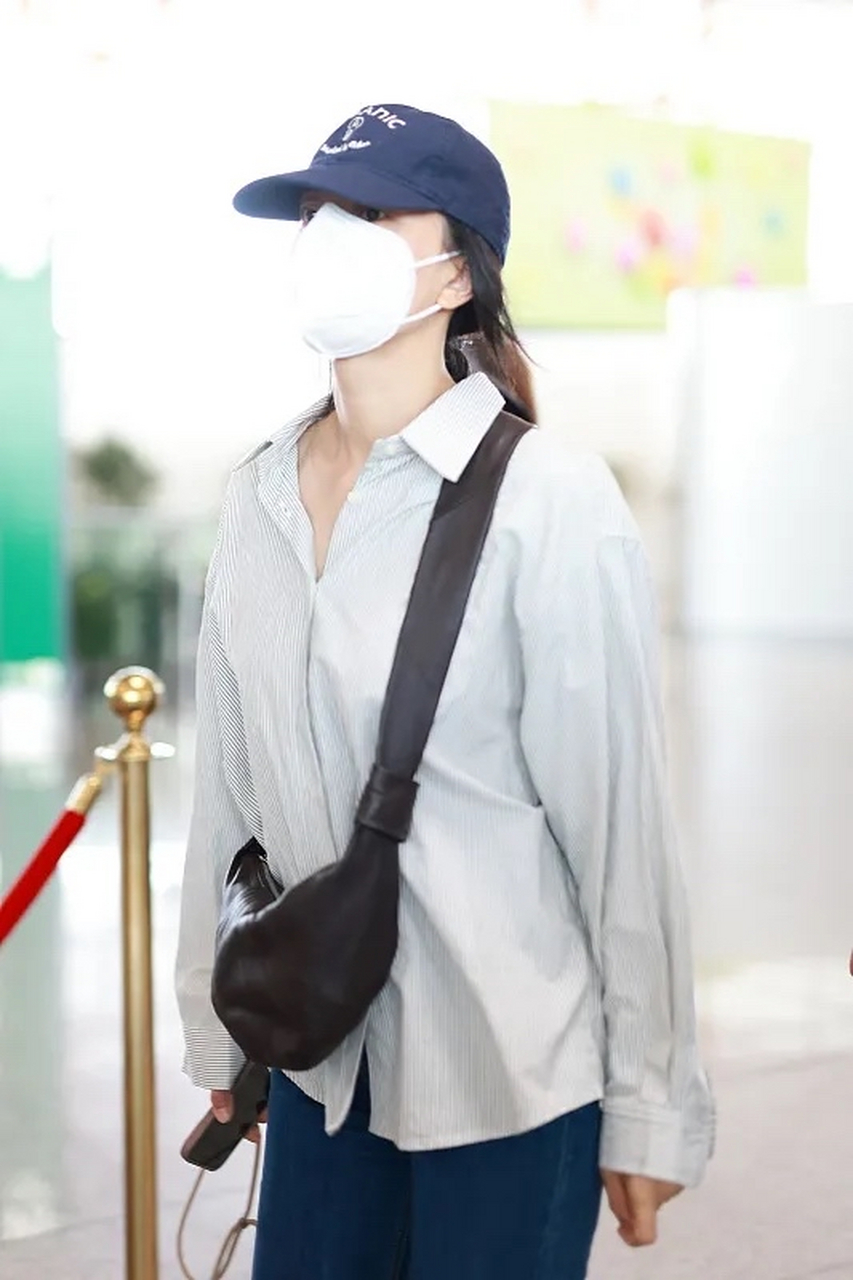 高圆圆最新街拍,她穿了一件白色条纹衬衫,搭配一条深蓝色的牛仔直筒裤