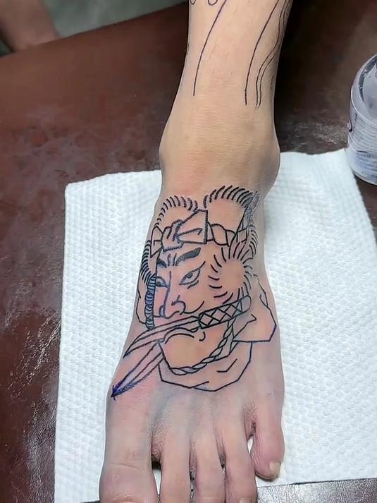 小伙子在脚背上纹身,疼痛程度难忍,一般人接受不了