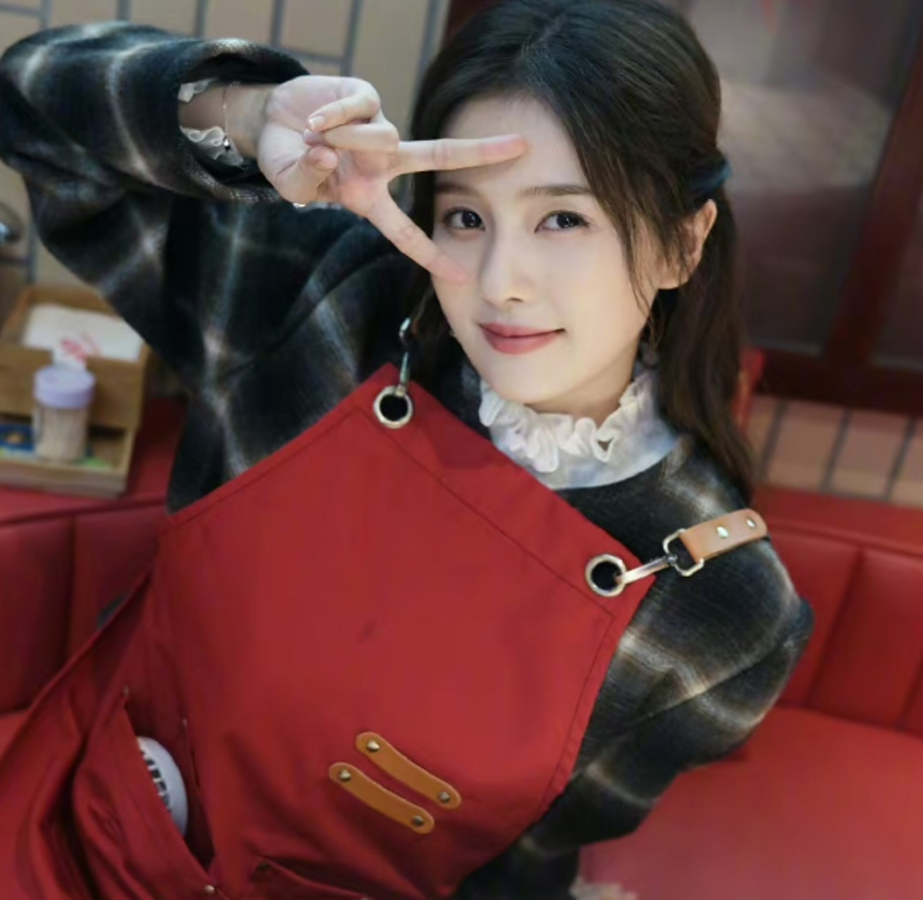 白鹿在剧组戴着围裙拍摄,休息时间歪头比耶可爱十足