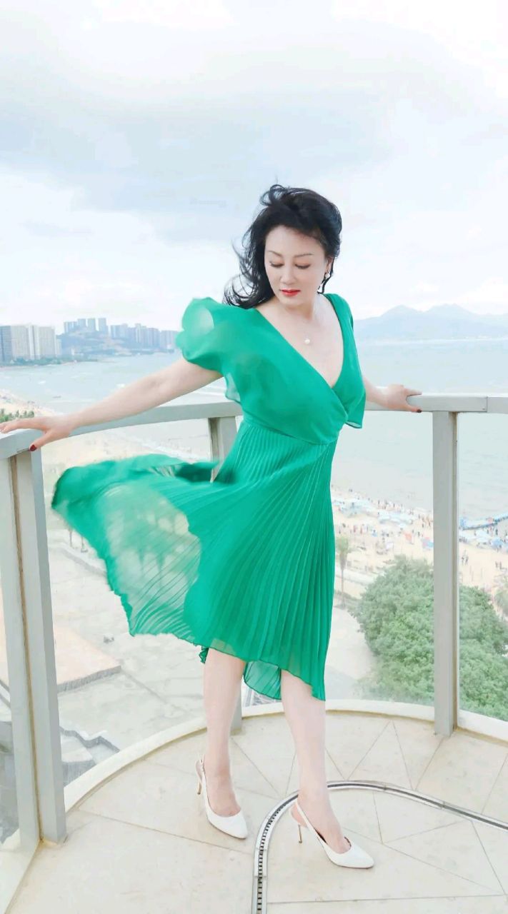 王姬在海边吹风,一袭绿色纱裙搭配白色高跟鞋,风情万种,优雅迷人,完全