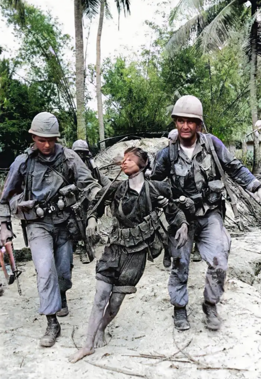 越南战争期间,两名美国大兵压着一名越南士兵,照片中,这名越南士兵