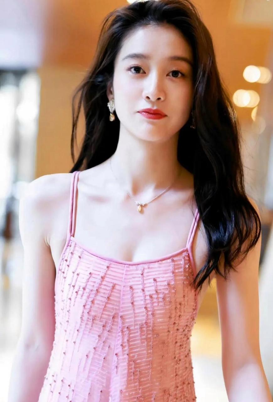 张雪迎这身粉色吊带长裙显得肤色格外白皙,披肩长发更是显得性感迷人.