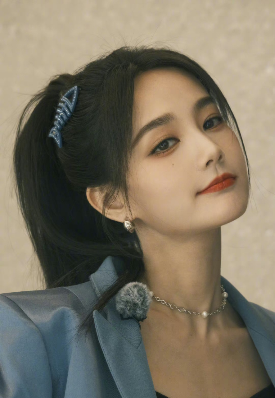 看李一桐这组照片,穿着蓝色套裙的李一桐梳着高马尾,戴着蓝色的鱼骨