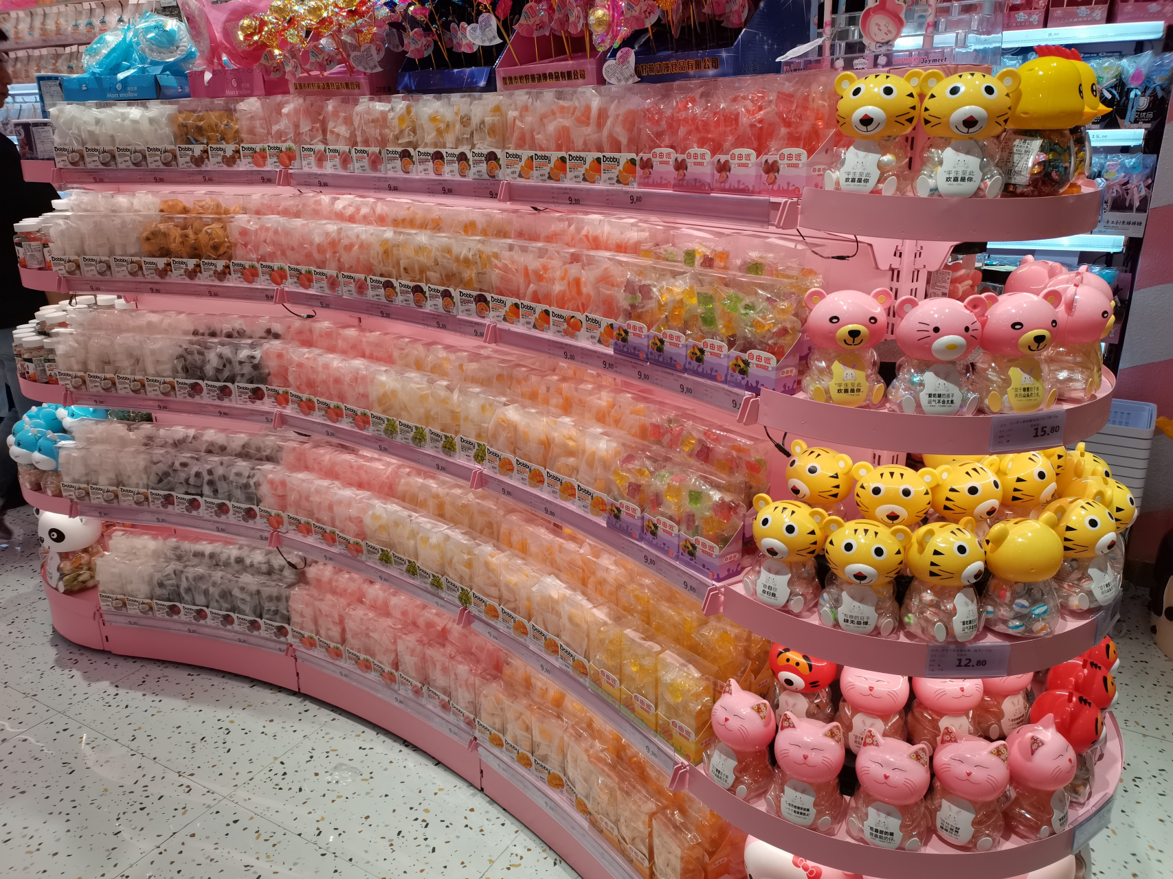 这是一家糖果店,一柱一柱的糖果五彩缤纷,果冻摆放得整整齐齐.