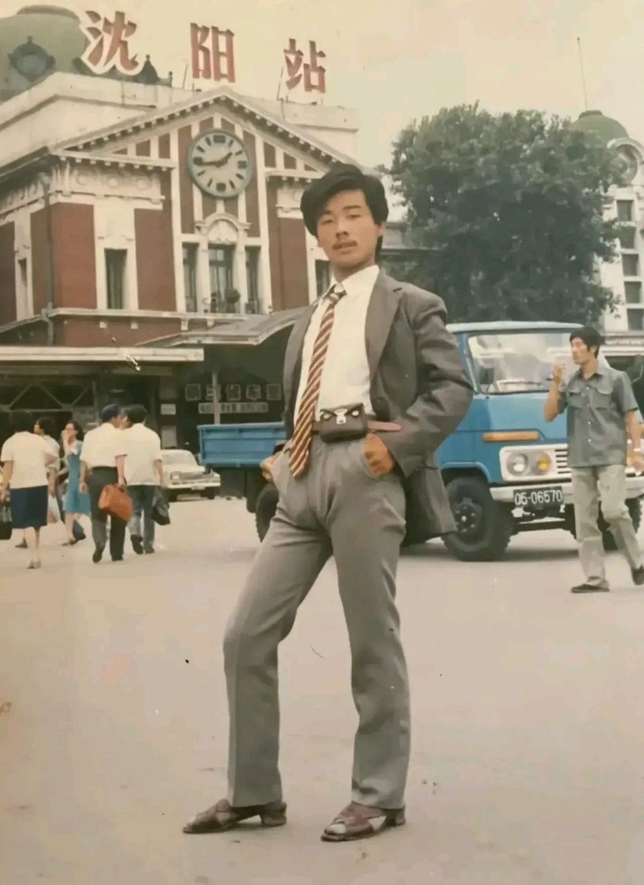 上世纪80年代的沈阳火车站广场上,一个西装革履的帅小伙的留影,小伙子