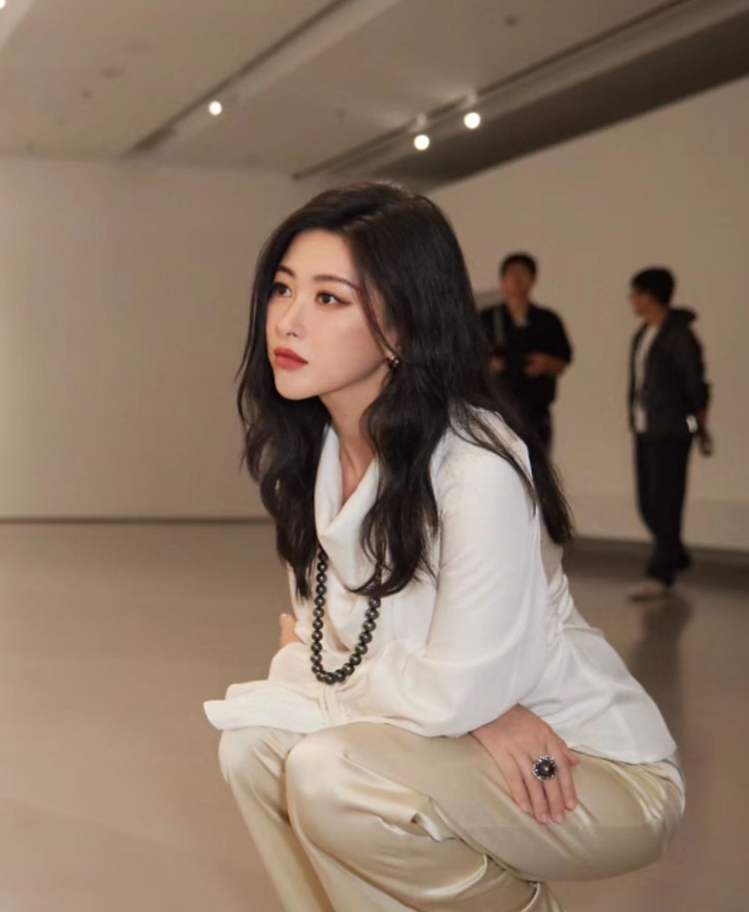 朱珠浓妆现身艺术活动,脖子上挂着串珠项链别出心裁,配合她的一身白色