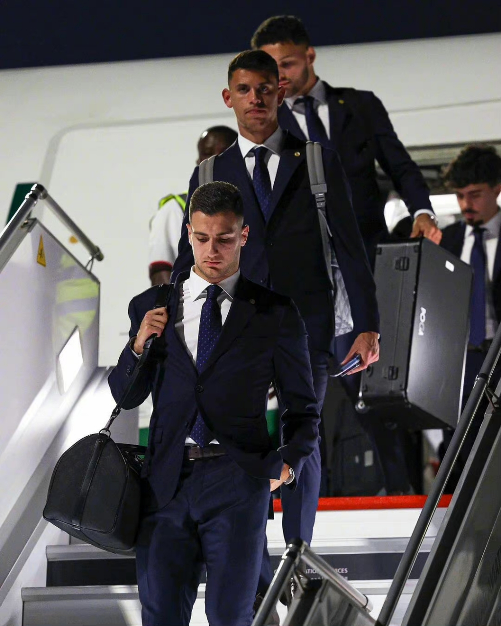 c罗身穿西装,手拉lv登机箱和队友们抵达卡塔尔