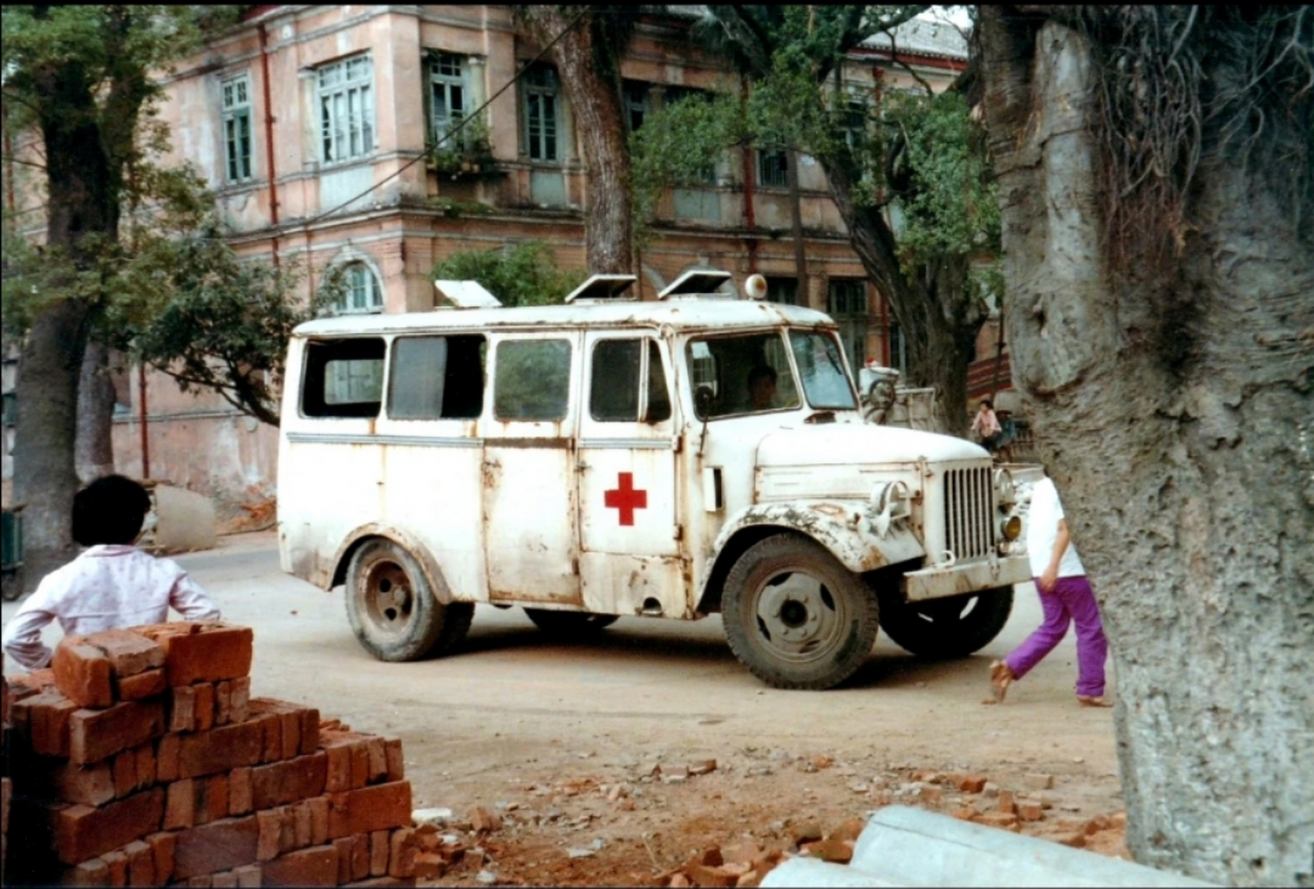 一白色的带着红十字标志的救护车停在路边,这就相当于现在的120.