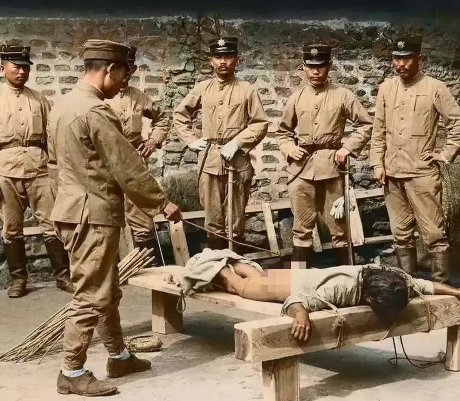 这张照片是在抗日战争期间,一名中国人被日本鬼子用绳子绑在木架上