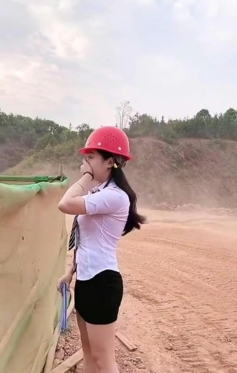 老板秘书来工地视察工作,正好一辆卡车经过,尘土飞扬,秘书连忙用手