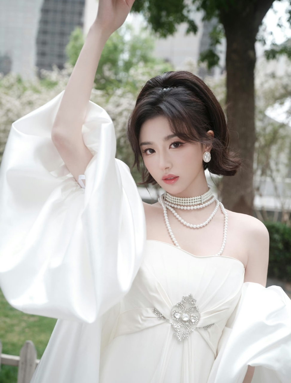 孔雪儿一袭白色抹胸长裙,搭配珍珠项链,高贵典雅,明艳动人,温柔中又带