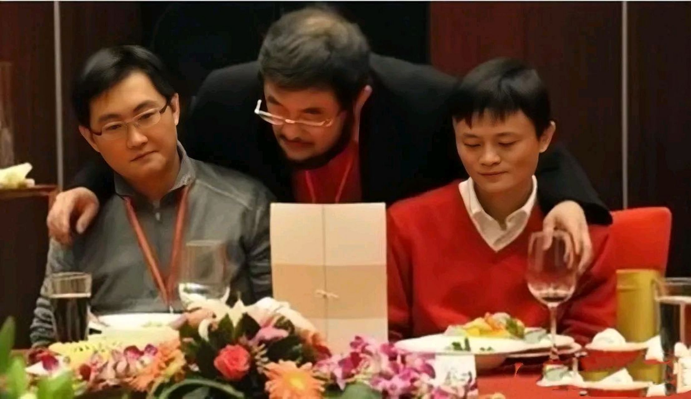 多年前,马云和马化腾参加宴会的照片,画面中他们相邻而坐,而一个戴着
