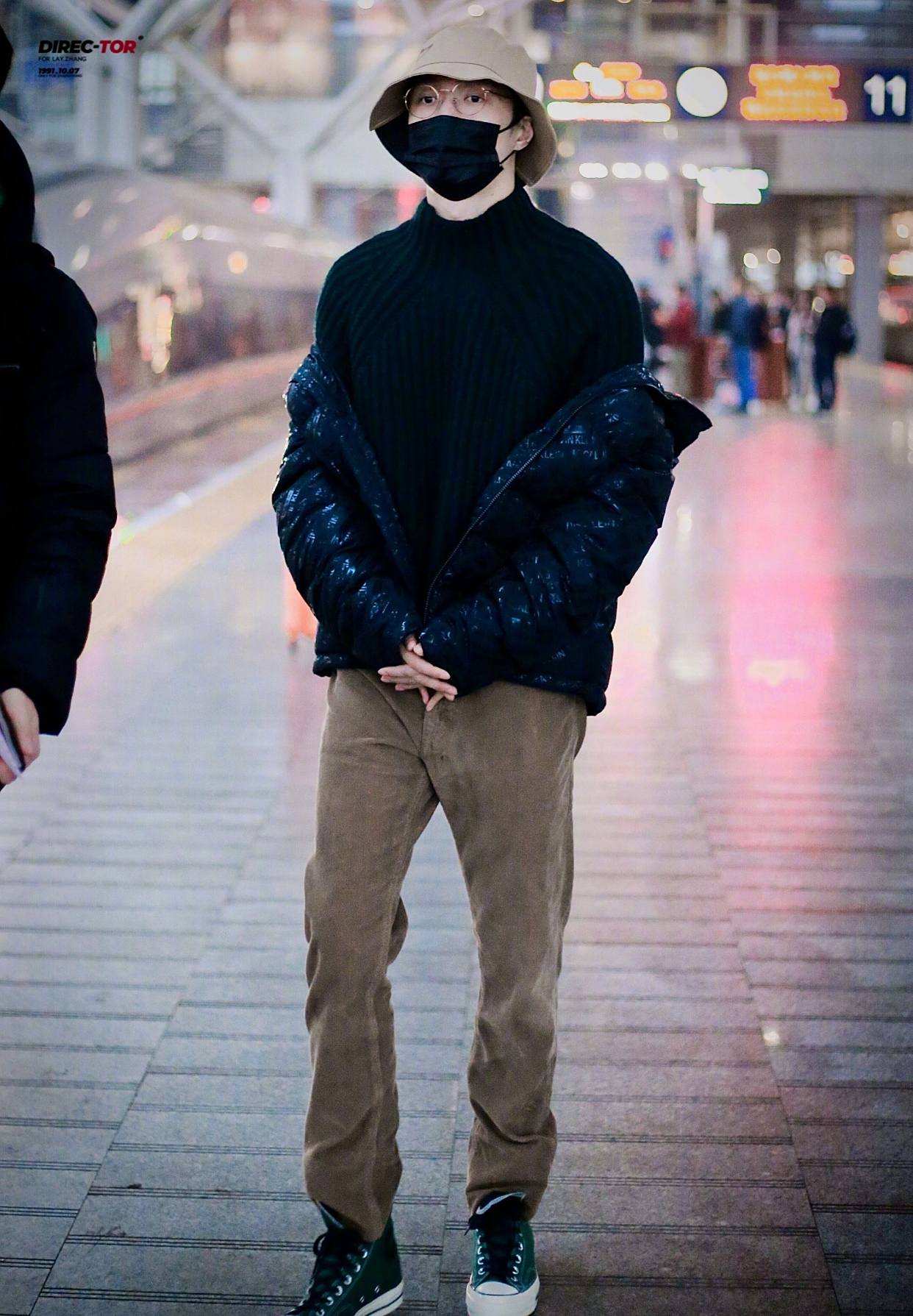 张艺兴行程饭拍图,身着深色毛衣配亮闪羽绒服,休闲舒适男友穿搭