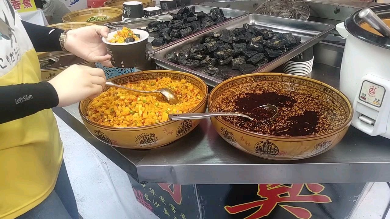 小两口慕名而来参观美食节,点了份长沙臭豆腐,那味道不言而喻