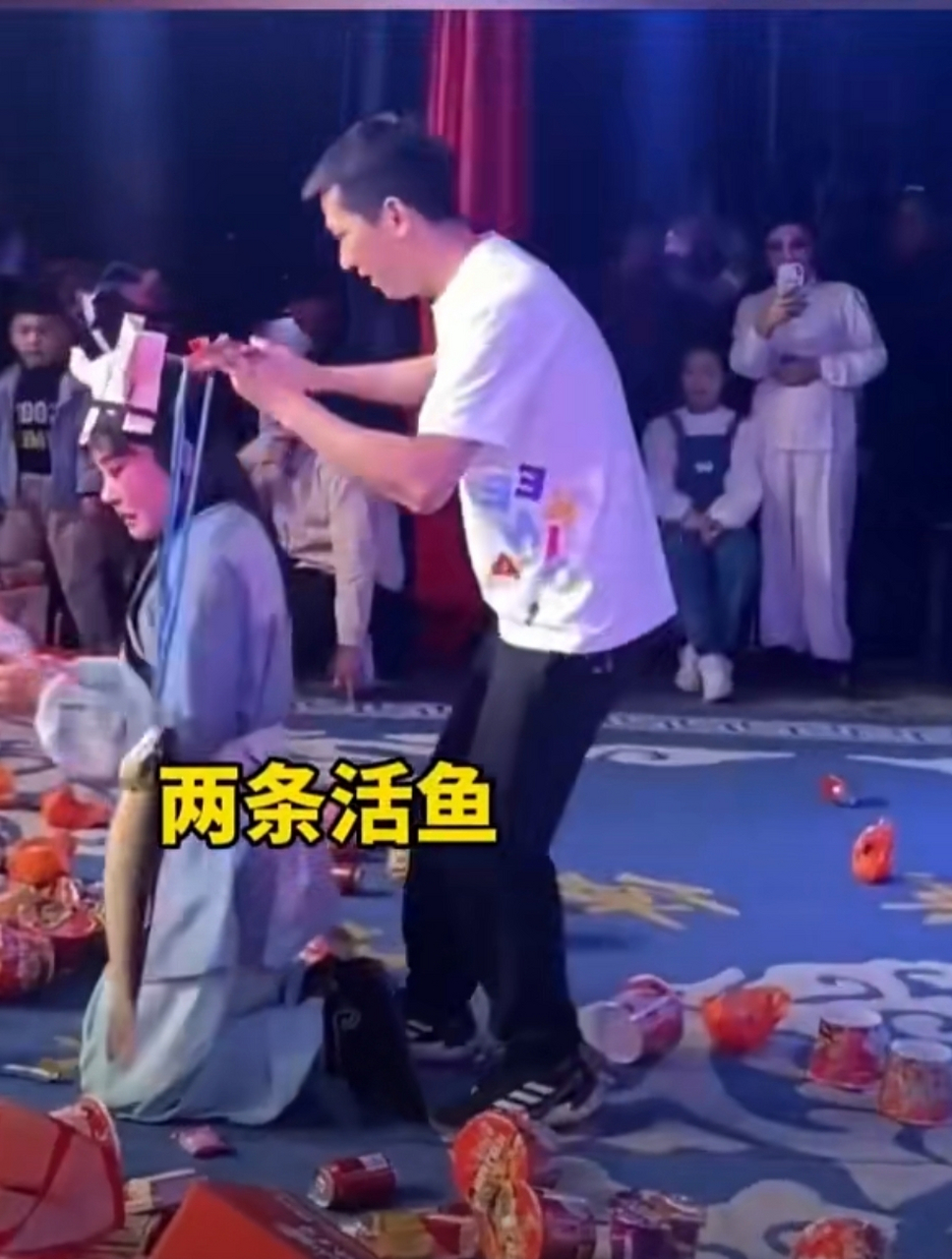 传统婺剧"讨饭戏"现场,台下观众纷纷打赏各类物品,甘蔗,鱼,泡面等.