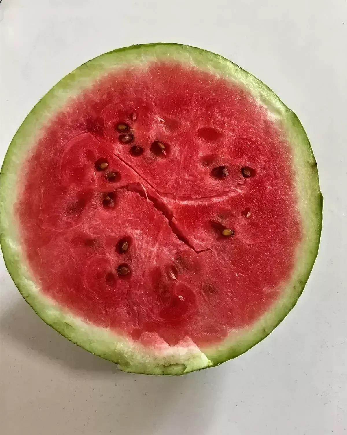 去超市购物我看见摆在摊位上切开的西瓜挺好的,一半半的红彤彤的看着