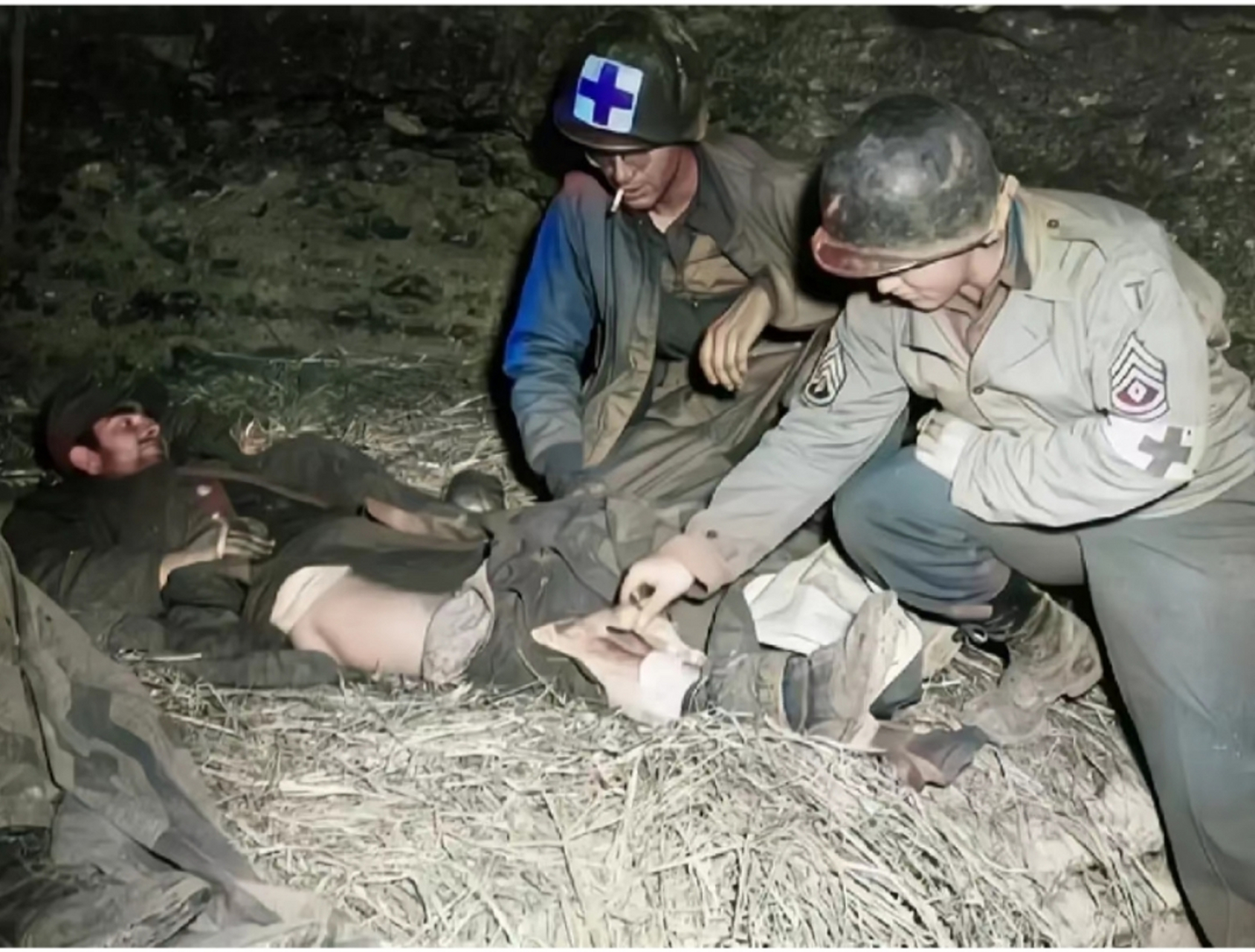 二战老照片,1943年,两名美军医护人员,在一座山洞里的草地上,发现一身