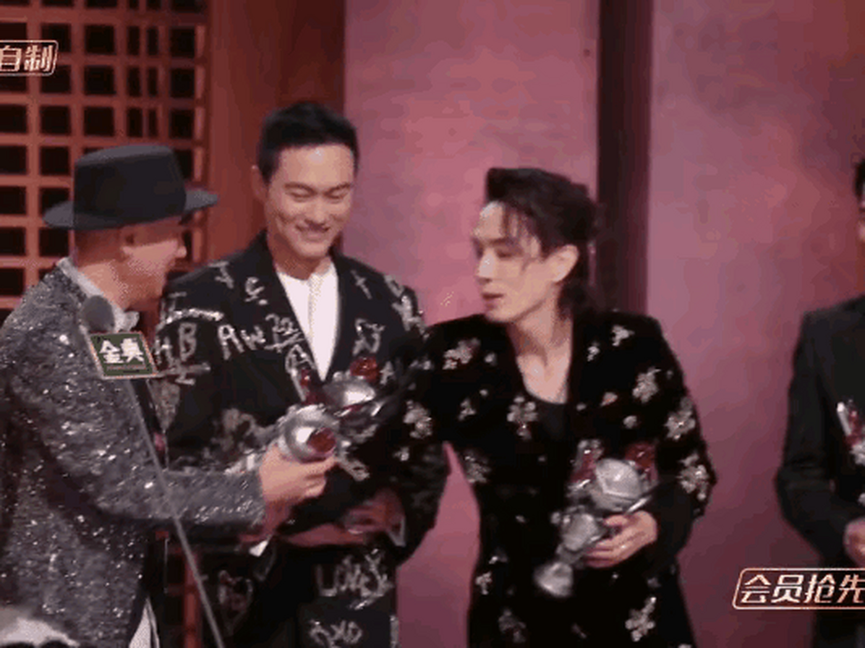 陈小春念完成团名单后,李承铉害怕陈小春怀里的奖杯掉落,于是连忙从