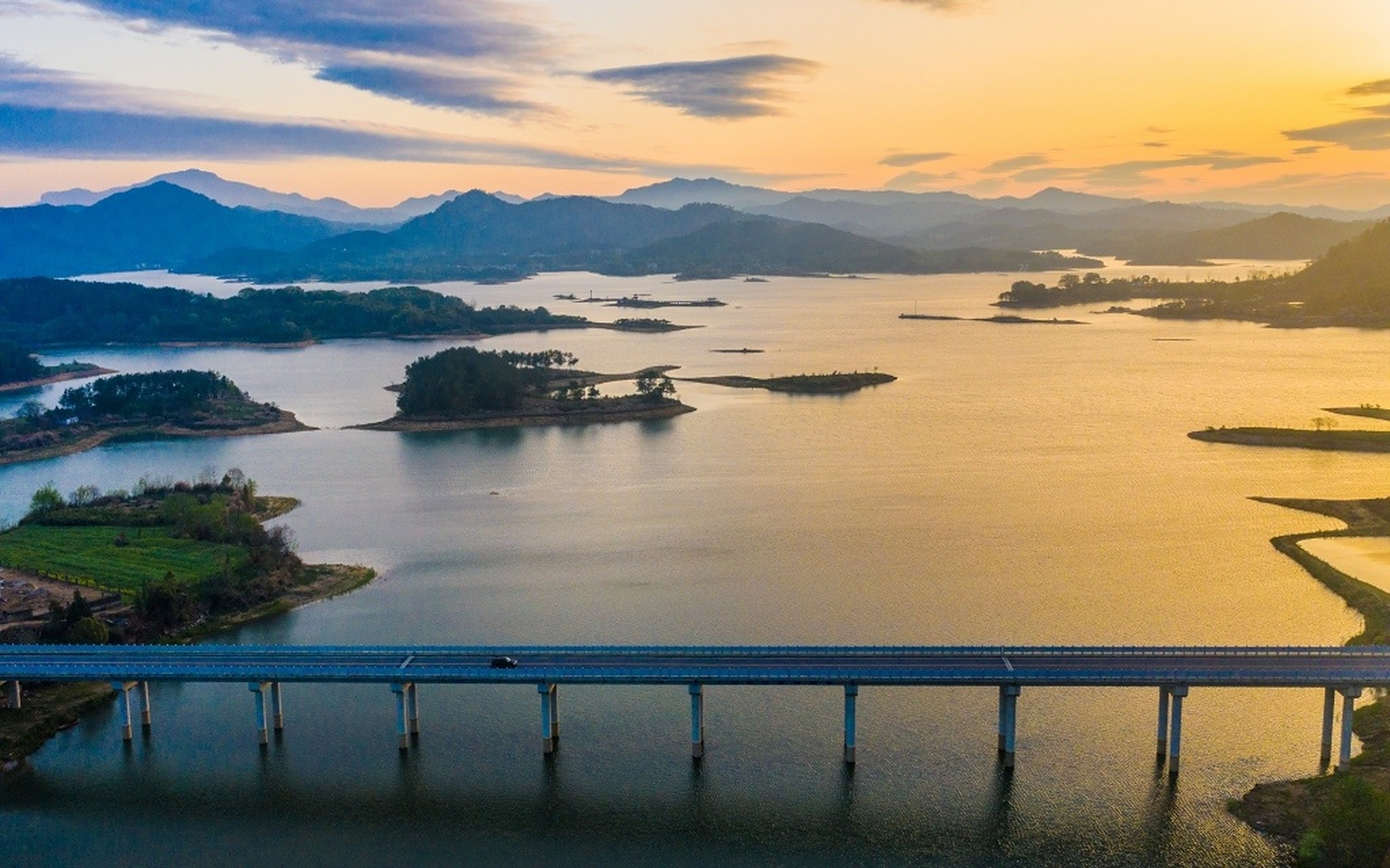 湖北黄冈,牛车河水库上空朝霞灿烂,映在平静的水面上,水天一色,蔚为