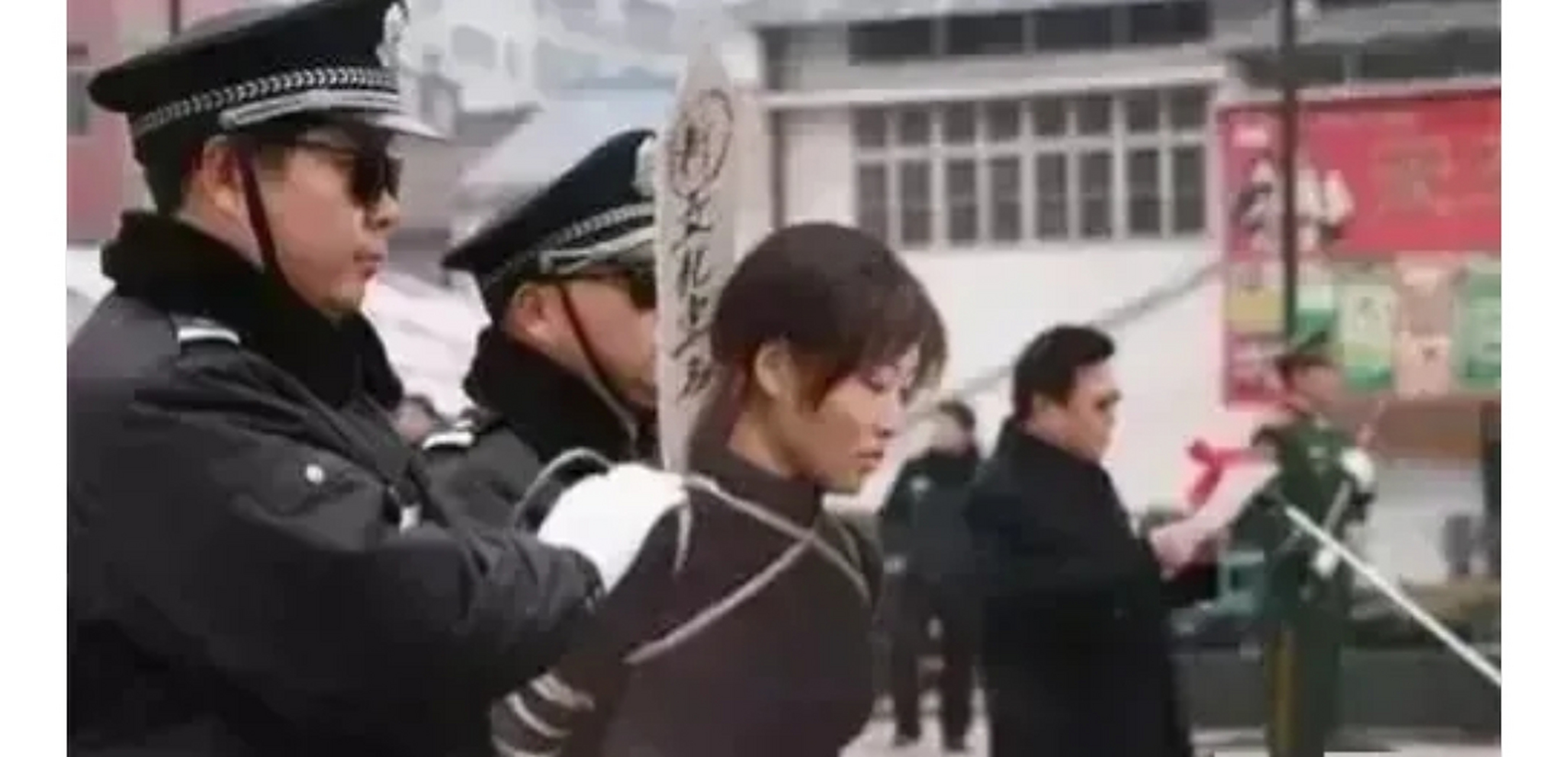 2003年,山东青岛,一名女犯人被五花大绑在公审大会上接受审判,镜头中