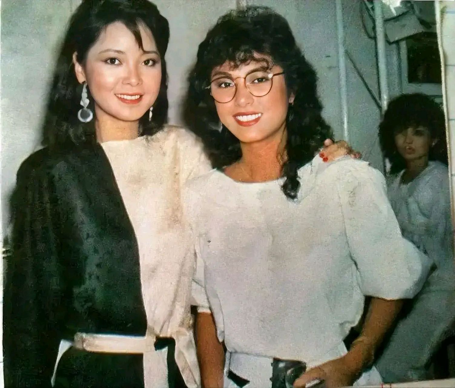 甜歌皇后和米雪的合影,照片中邓丽君穿着一件藏绿色和白色长裙,戴着一
