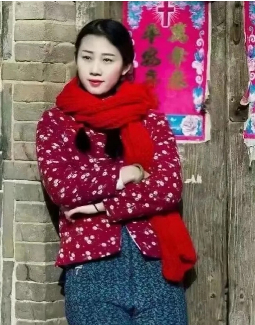 历史老照片,二十世纪八十年代,一位穿着红色花棉袄,蓝色带点的裤子,戴