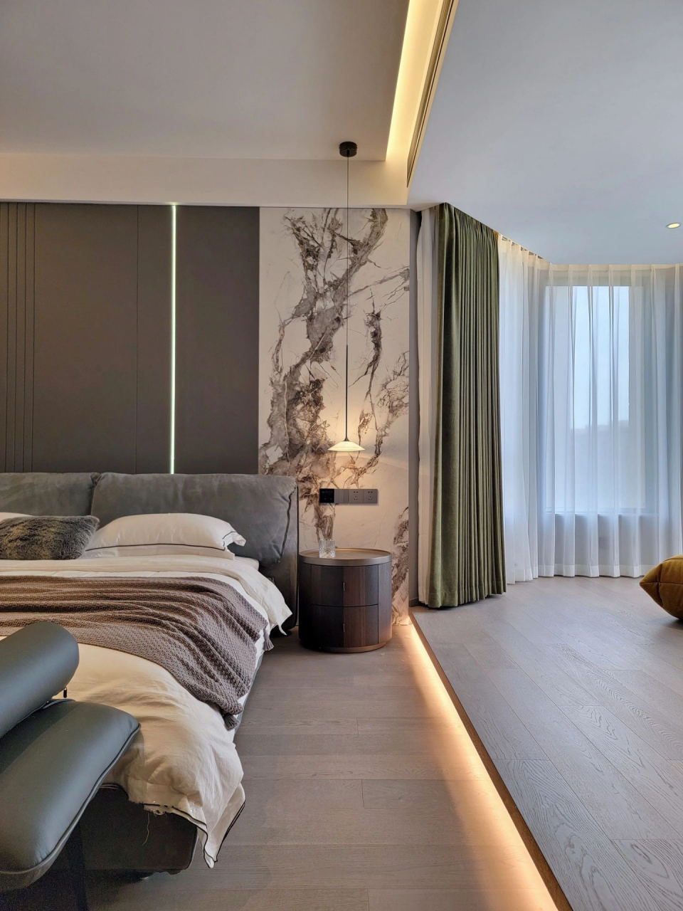 现代轻奢风主卧装修,墙面用木饰面和岩板拼接,避免了单调的同时传递