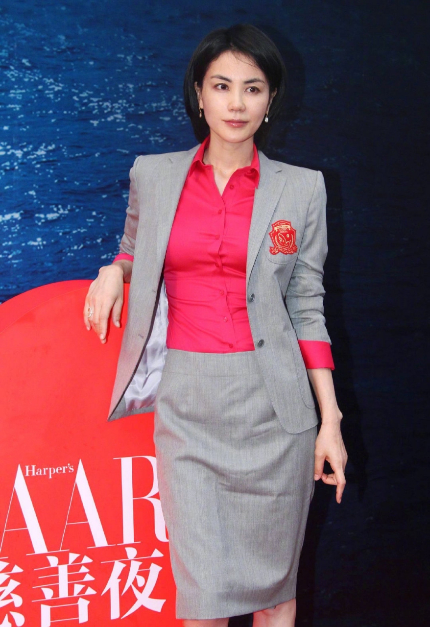 王菲早年出席慈善夜活动的造型,身穿灰色西服套裙,内搭茶花红衬衫