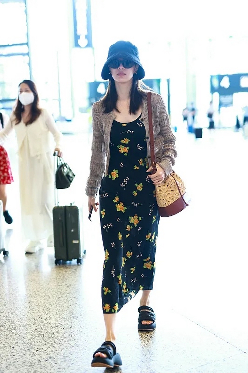 钟楚曦街拍,她戴了一顶深蓝色的渔夫帽,穿一件灰褐色的短款针织开衫