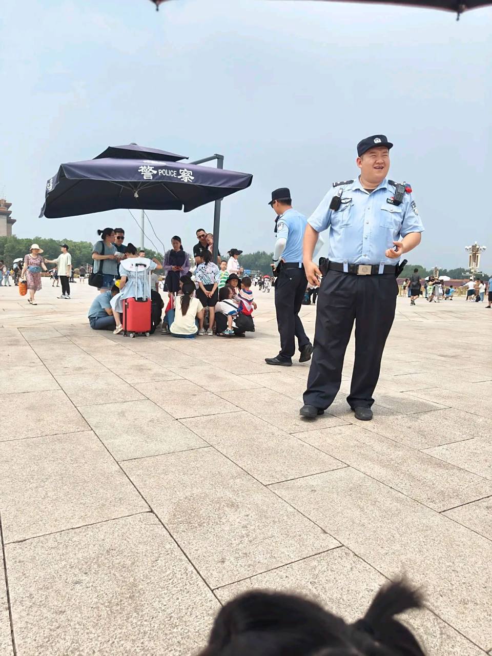 天安门广场,警察叔叔把遮阳棚让给了游客,自己浑身是汗 #正能量
