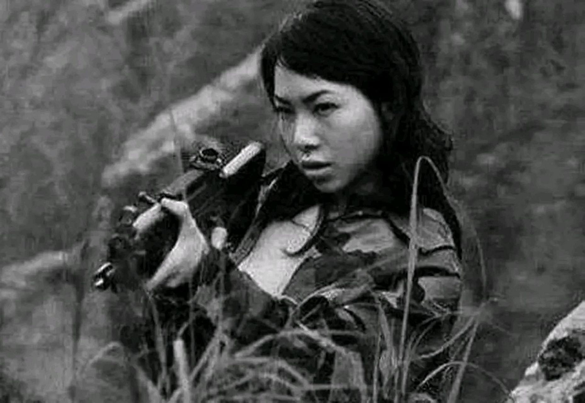 1969年美越战场一名越南女特务趴在草丛里埋伏美军时被摄像师捕捉