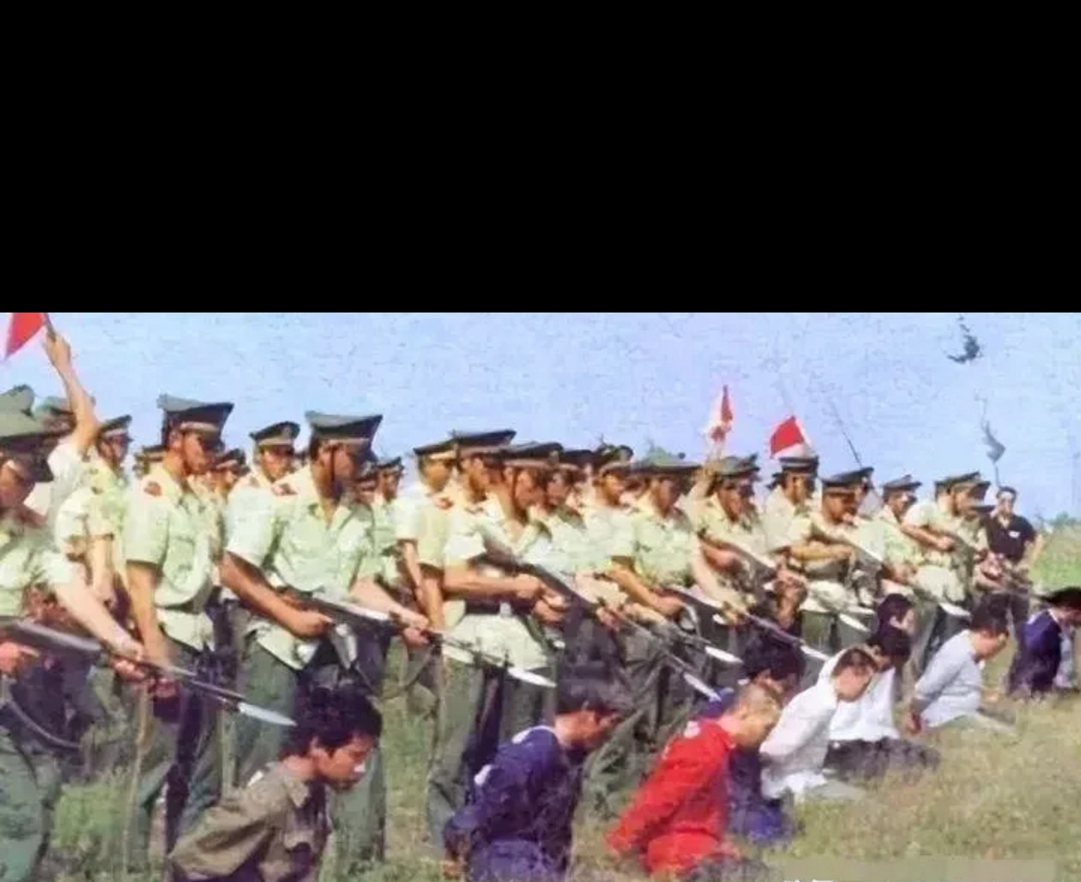 80年代严打时期,某地刑场里正对死刑犯人进行集体枪决.