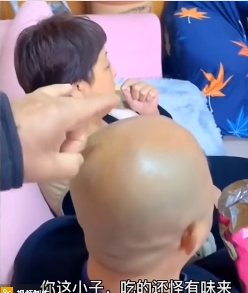 光头中年男子在沙发看电视,头上被弹脑瓜崩,正想大怒回头却笑了