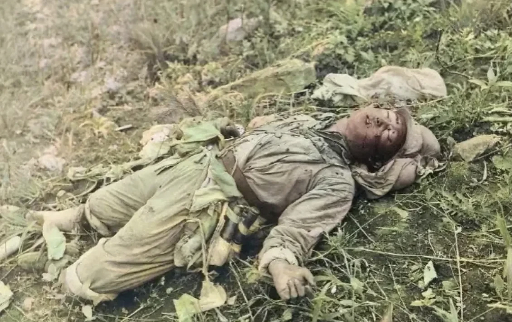 照片中躺在地上的是一名牺牲的志愿军战士,他单薄的军衣,简陋的武器